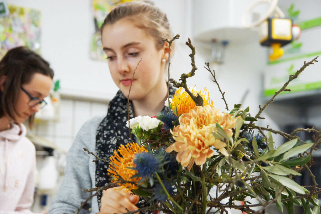 Floristik-Auszubildende bindet einen Blumenstrauß