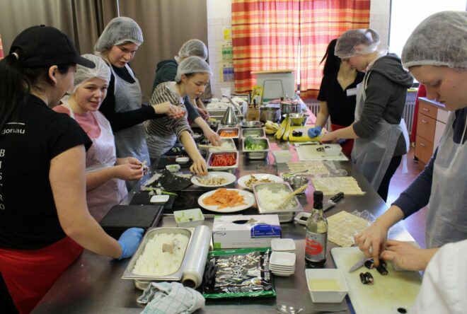 Schülerinnen beim Zubereiten von Sushi