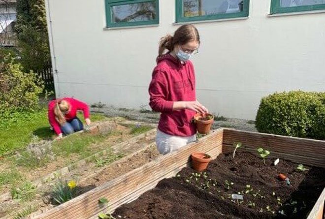 Schülerin bei der Arbeit im Schulgarten